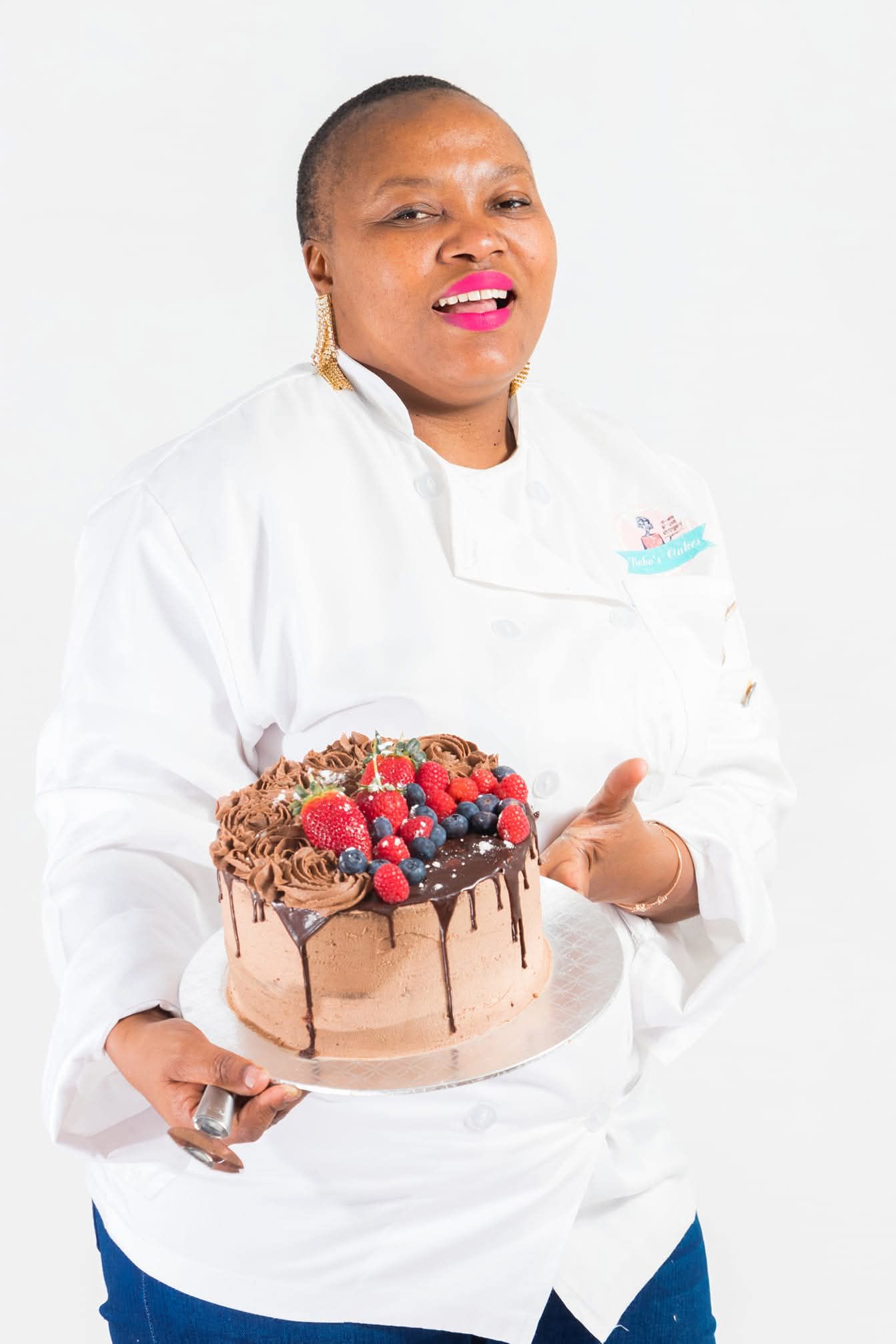Chef Bobo of Bobo's Cakes holding a chocolate berry drip cake